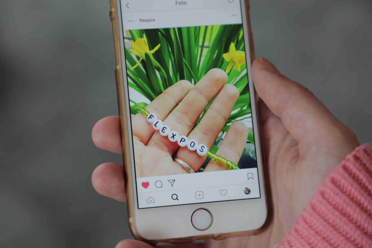 Social Media Marketing: Handybildschirm mit Instagram-Bild; darauf zu sehen ist ein grünes Armband mit der Aufschrift "flexpos". Copyright by Sarah Dunkel